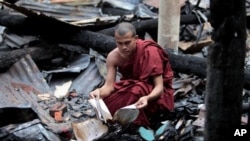 Seorang biksu Buddha Bangladesh memeriksa sisa-sisa buku agama yang terbakar habis bersama kuil Buddha dalam serangan hari Sabtu dan Minggu di Ramu, wilayah Cox's Bazar, Bangladesh (1/10).