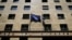 A European Union flag (L) flutters next to a Greek flag on the facade of the Bank of Greece headquarters in Athens, April 14, 2015.