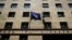 FILE - A European Union flag (L) flutters next to a Greek flag on the facade of the Bank of Greece headquarters in Athens, April 14, 2015.