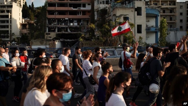在贝鲁特爆炸现场附近,人们游行纪念死难者。(2020年8月11日)