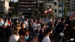 Warga Lebanon berkumpul untuk menghormati 150 korban tewas dalam ledakan dahsyat di Beirut, hari Jumat (11/8). 