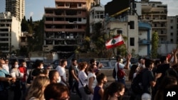 People march in honor of the victims of the last week's explosion that killed over 150 people and devastated the city, near the blast site in Beirut, Lebanon, Aug. 11, 2020.
