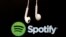FILE - Headphones are seen in front of a logo of online music streaming service Spotify.