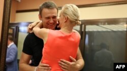 Russia's top opposition leader Alexei Navalny hugs his wife Yulia in the courtroom in Kirov, July 19, 2013. 