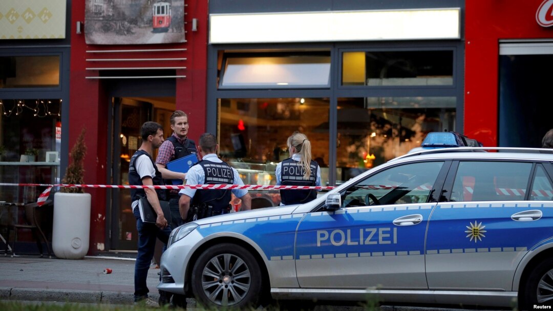 Police stand outside where a 21-year-old Syrian refugee killed a woman with a machete and injured two other people in the city of Reutlingen, Germany, July 24, 2016.