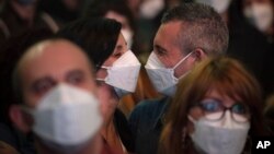 People using face masks attend a music concert in Barcelona, Spain, Saturday, March 27, 2021. Five thousand music lovers were set to attend a rock concert in Barcelona on Saturday after passing a same-day COVID-19 screening to test its effectiveness…