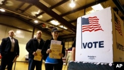 FILE - In this March 15, 2016, file photo, people line up to vote in the primary at a precinct in Bradfordton, Il. 