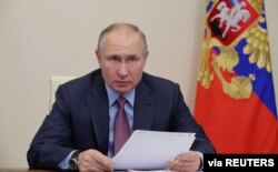 FILE - Russian President Vladimir Putin chairs a video-conference meeting at Novo-Ogaryovo state residence outside Moscow, Russia, Feb. 10, 2021.