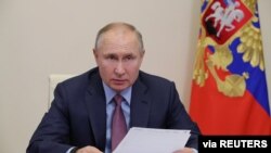 FILE - Russian President Vladimir Putin chairs a meeting with government members via a video conference call at Novo-Ogaryovo state residence outside Moscow, Russia, Feb. 10, 2021.