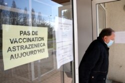 A man leaves a vaccination site with a sign reading "No vaccination with the AstraZeneca vaccine today," in Saint-Jean-de-Luz, southwestern France, March 16, 2021.