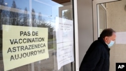 A man leaves a vaccination site with a sign reading "No vaccination with the AstraZeneca vaccine today," in Saint-Jean-de-Luz, southwestern France, March 16, 2021. 