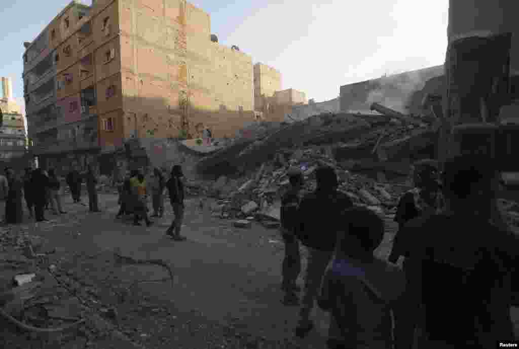 Civilians gather at a site of a collapsed building that activists said was shelled by forces loyal to Syria's President Bashar al-Assad in Deir al-Zor, October 14, 2013.