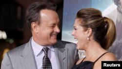 FILE - Actor Tom Hanks poses with wife, actress Rita Wilson, as they arrive for a film premiere in Hollywood, Oct. 24, 2012.