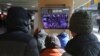 People watch a TV screen showing the news on a violent mob that loyal to U.S. President Donald Trump stormed the U.S. Capitol, at the Seoul Railway Station in Seoul, South Korea, Thursday, Jan. 7, 2021. (AP Photo/Ahn Young-joon)