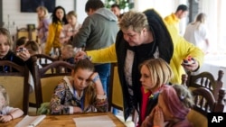 FILE - Nina Poliakova speaks to her foster daughter Olha Hinkina at a recovery camp for children and their mothers affected by the war, near Lviv, Ukraine, on May 3, 2023.