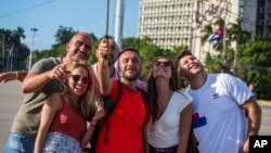 Des touristes prennent une photo sur la place de la Révolution à la Havane, Cuba, le 27 novembre 2016.