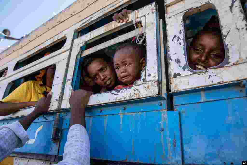 Refugees who fled the conflict in Ethiopia's Tigray region, ride a bus going to the Village 8 temporary shelter, near the Sudan-Ethiopia border, in Hamdayet, Sudan, Dec. 1, 2020.