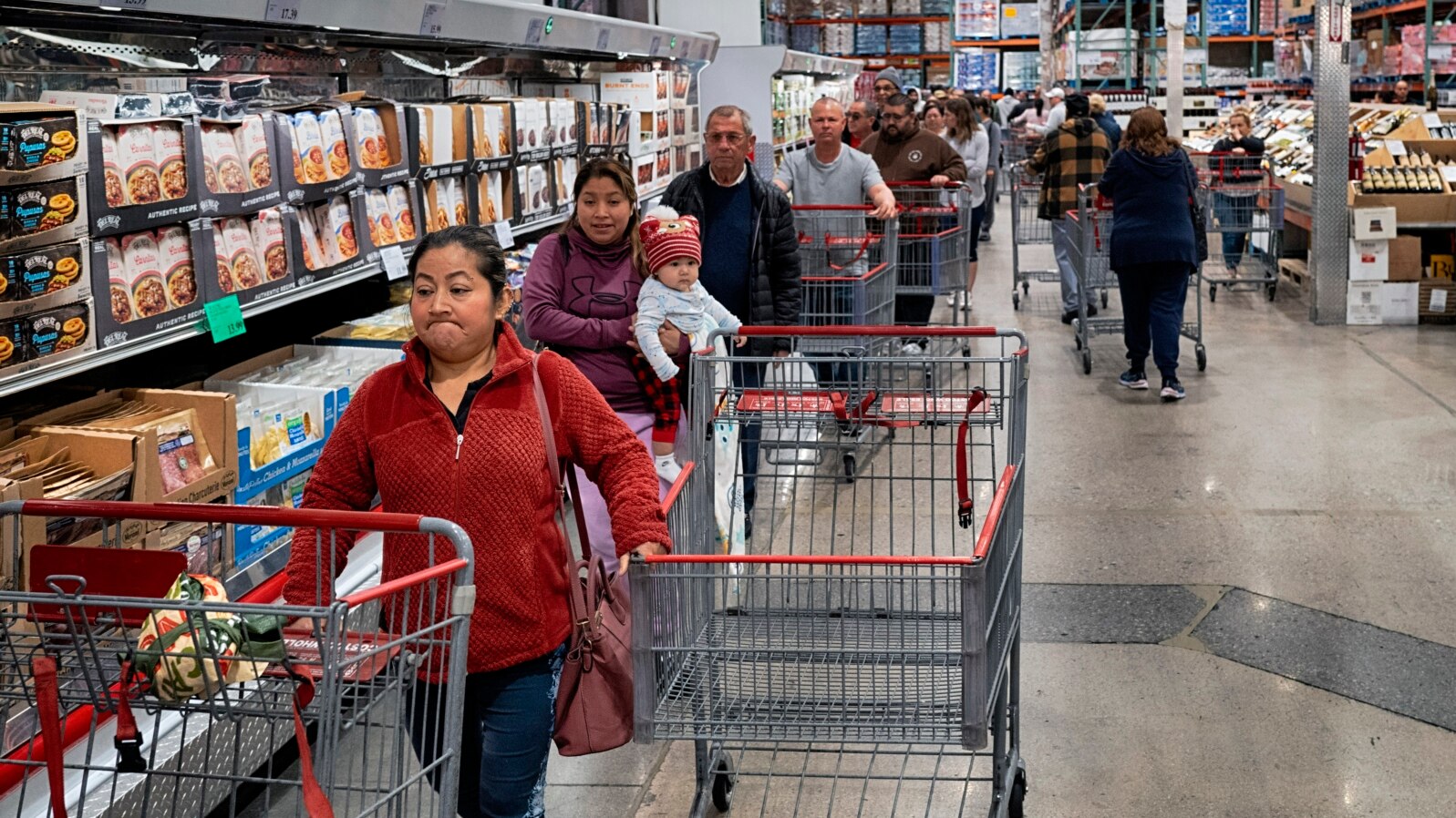 ARCHIVO - Consumidores esperan para pagar por sus compras en una tienda Costco en Los Ángeles, el 19 de febrero de 2025.