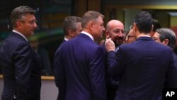 El presidente del Consejo Europeo, Charles Michel, en el centro, es recibido por el primer ministro español, Pedro Sánchez, de segunda derecha, y el presidente rumano, Klaus Werner Ioannis, de centro izquierda, durante una reunión de mesa redonda en una c