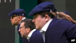 FILE - Line judges concentrate during a first round men's singles match on day three of the Wimbledon tennis championships in London, July 5, 2023. Humans will be replaced by artificial intelligence to make the calls beginning in 2025. 