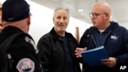 Entertainer and activist Jon Stewart, center, speaks with members of the FealGood Foundation as they arrive on Capitol Hill to speak with lawmakers about the compensation fund for victims of 9/11, Feb. 25, 2019, on Capitol Hill in Washington.