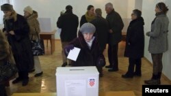 A woman casts her ballot at a polling station during the presidential election in Zagreb December 28, 2014. Croats were voting for a new head of state on Sunday but none of the four candidates for the largely ceremonial post in the European Union's newest