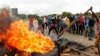 FILE: Protestors gather near a burning tire during a demonstration over the hike in fuel prices in Harare, Zimbabwe, Tuesday, Jan. 15, 2019. A Zimbabwean military helicopter on Tuesday fired tear gas at demonstrators blocking a road and burning tires in the capital.