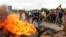 FILE: Protestors gather near a burning tire during a demonstration over the hike in fuel prices in Harare, Zimbabwe, Tuesday, Jan. 15, 2019. A Zimbabwean military helicopter on Tuesday fired tear gas at demonstrators blocking a road and burning tires in the capital.