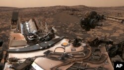 FILE - This composite image from Aug. 9, 2018 photos made available by NASA shows the Curiosity rover at Vera Rubin Ridge on Mars.