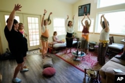 Members of a prenatal group at The Farm Midwifery Center dance during a meeting Thursday, Aug. 31, 2023, in Summertown, Tenn.