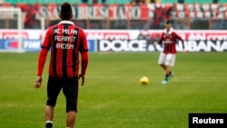 AC Milan's Kevin Prince Boateng (L), wearing a jersey against racism, and Stephan El Shaarawy warm up before their match against Siena in Milan Jan. 6, 2013.