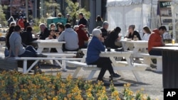 Patrons enjoy lunch at a market in Christchurch, New Zealand, Aug. 9, 2020, as the country marked 100 days of being free from the coronavirus, with just a few infections continuing to be picked up at ports of entry where people are quarantined.