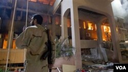 solda libyen kanpe devan yon bilding aprè yon atak ayeryen (AP Photo/Darko Bandic)