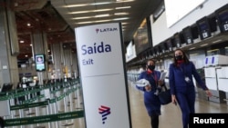 En esta imagen del 19 de mayo de 2020 se ve a empleados de Latam Airlines en la sala de embarque en el Aeropuerto Internacional Guarulhos, en Sao Paulo, Brasil.