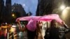 People shield themselves with a plastic rain poncho during a rainstorm in New York City, Aug. 6, 2024. 