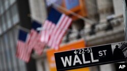 FILE - A sign for Wall Street is seen in front of the New York Stock Exchange, in New York City, Jan. 31, 2020.