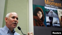 El fotógrafo estadounidense Steve McCurry habla en su exposición fotográfica en el Museo de la Civilización Asiática en Singapur el 26 de junio de 2009. Al fondo la foto que le catapultó a la fama con la imagen de la niña Sharbat Gula .