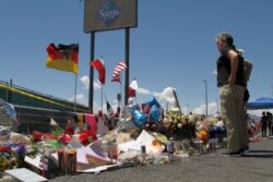 FILE - Mourners visit the makeshift memorial near the Walmart in El Paso, Texas, Aug. 12, 2019, where 22 people were killed in a mass shooting.