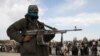  A member of the Taliban stands with others at the execution of three men in Ghazni Province, April 18, 2015. Residents of the area say Islamic State has threatened them to stop supporting the Taliban and support Islamic State instead.