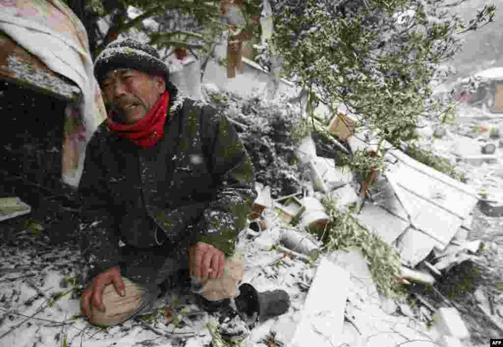 Город Онагава. Пострадавший оплакивает членов своей семьи, погребенных под завалами его дома. 17 марта 2011 год