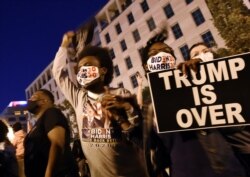 FILE - African American supporters of president-elect Joe Biden celebrate on Black Lives Matter Plaza across from the White House in Washington, Nov. 7, 2020, after Biden was projected the winner of the 2020 presidential election.