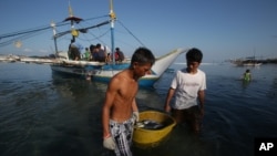 Nelayan Filipina membawa hasil tangkapannya di pesisir Pantai Infanta, Pangasinan, di barat laut Filipina (7/5). Para nelayan Filipina mengatakan kapal-kapal pengawas China telah mengusir mereka dari wilayah yang disengketakan di Laut China Selatan, yang sebelumnya selama bertahun-tahun telah menjadi tempat mereka menangkap ikan. 