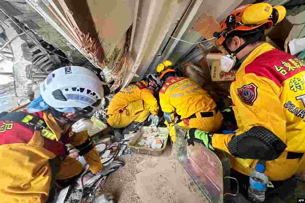 This handout from the Hualien Fire Department taken and released on April 3, 2024 shows members of a rescue team searching for survivors in a damaged building in Hualien, after a major earthquake hit Taiwan&#39;s east.