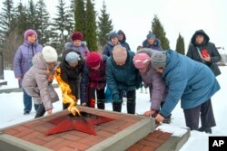 Women lay flowers at the Eternal Flame military memorial in Yablonovo, Belgorad region, Russia, on Jan. 25, 2024, in memory of those who were killed in the downing of a plane the day before in the area.