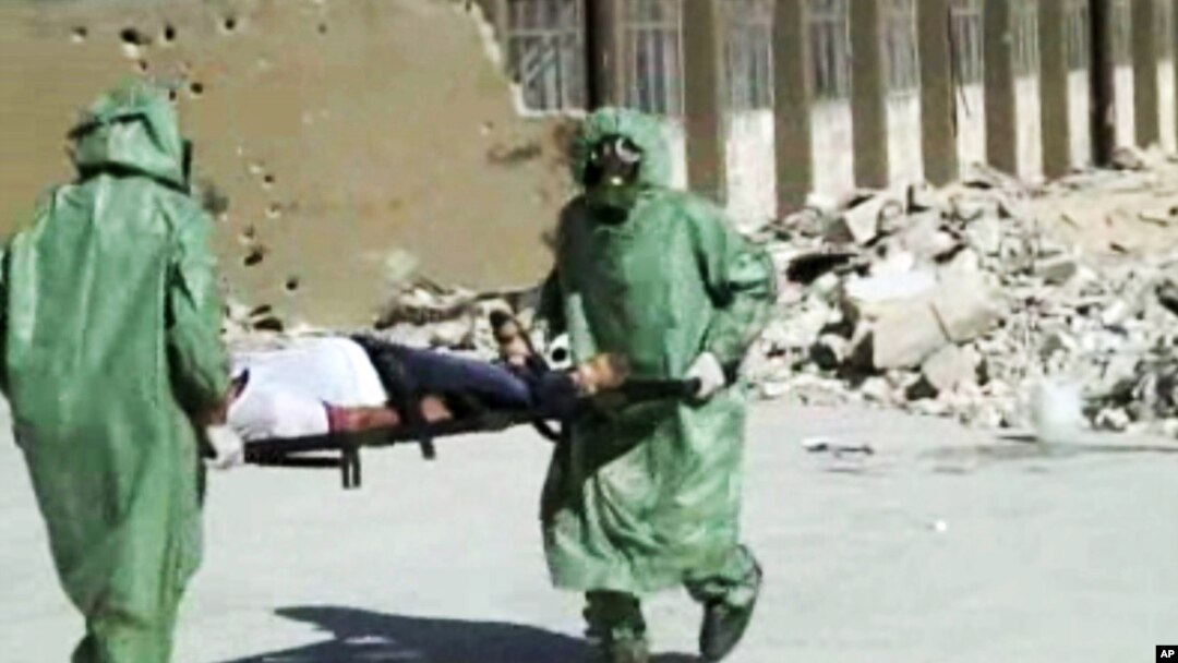 Orang-orang dengan baju pelindung dan masker gas melakukan pelatihan penyelamatan korban gas berancun di Aleppo, Suriah. (Foto: dok.)