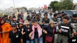 FILE - Cambodian civil rights supporters are forcibly directed by riot police as they march in protest of charges brought against local rights activists near Prey Sar prison, outside Phnom Penh, Cambodia, May 9, 2016. 