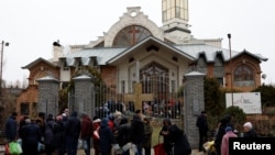 Ljudi čekaju u redu da People wait in line to get food, water and aid after Russia's military retreat from Kherson, outside the Church of Christ the Savior in Kherson, Ukraine November 22, 2022.