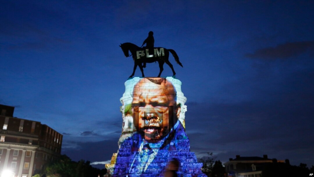 Gambar mendiang Anggota Kongres Georgia dan perintis hak-hak sipil Perwakilan AS John Lewis diproyeksikan ke alas patung konfederasi Jenderal Robert E. Lee di Monument Avenue, di Richmond, Va, Rabu, 22 Juli 2020. (Foto: dok).