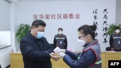 시진핑 중국 국가주석이 10일 신종 코로나 사태 대응 점검을 위해 베이징 지역 사회를 방문한 가운데 의료 관계자가 시진핑 주석의 체온을 재고 있다. 