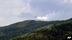 سائیبریا کے جنوبی حصے میں واقع ایک نیشنل پارک کے درختوں پر ایک روسی ہیلی کاپٹر پانی کا سپرے کر رہا ہے۔ 10 جولائی 2020